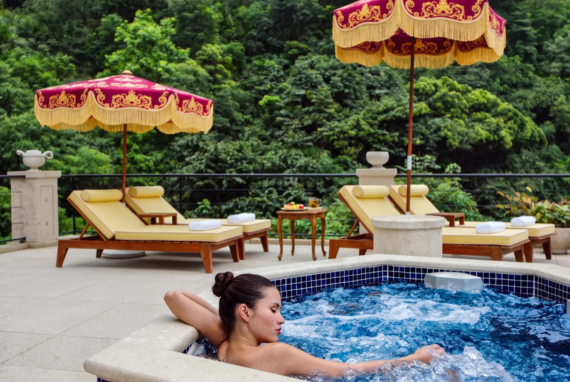 Jacuzzi terrace with fringed parasols above a rainforest valley